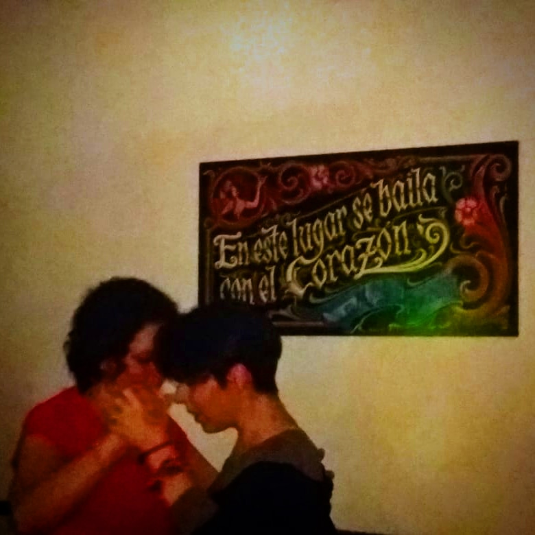 Bailarinas de tango con un cartel de fondo "en este lugar se baila con el corazón"